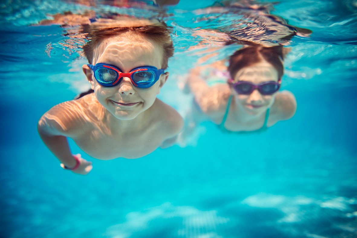 LOWO Sonnenlift - Hochwertige Schwimmbadüberdachungen 2 Kinder die in einem Pool schwimmen.